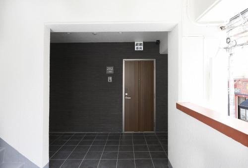 a hallway with a brown door in a building at コンドミニアムHARU 那覇県庁前 201 in Naha