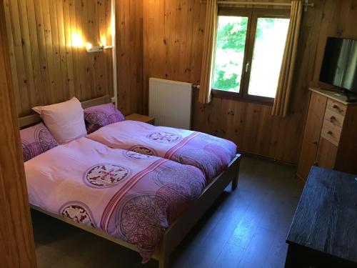 Tempat tidur dalam kamar di HÔTEL RESTAURANT LA FOURMI
