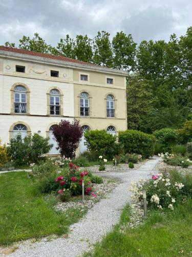 einen Garten mit Blumen vor einem Gebäude in der Unterkunft Le Studio du Château in Auriac-sur-Vendinelle