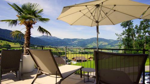 a patio with a table and an umbrella at Hotel St Hubertus in Egg