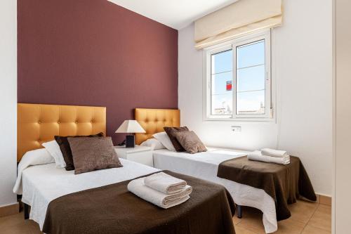 a bedroom with two beds and a window at Home Vejer in Vejer de la Frontera