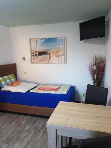 ein kleines Zimmer mit einem Bett und einem Tisch in der Unterkunft Fewo am Achterwasser in Zempin