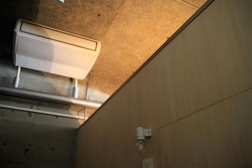 a light on the side of a wall in a bathroom at Iwashi Building Hostel in Akune