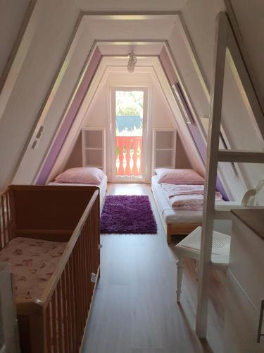 a attic room with two beds and a window at Ferienhaus am Helenesee 5 in Frankfurt Oder