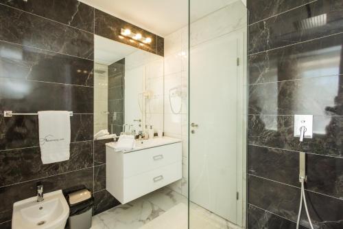 een badkamer met een toilet, een wastafel en een douche bij Aparthotel Gimi in Mošćenička Draga