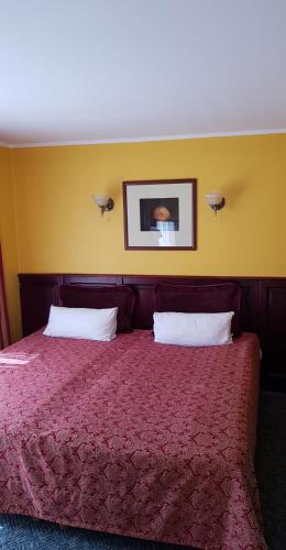 a bedroom with a red bed with two pillows at Vila Florena Garden in Palanga