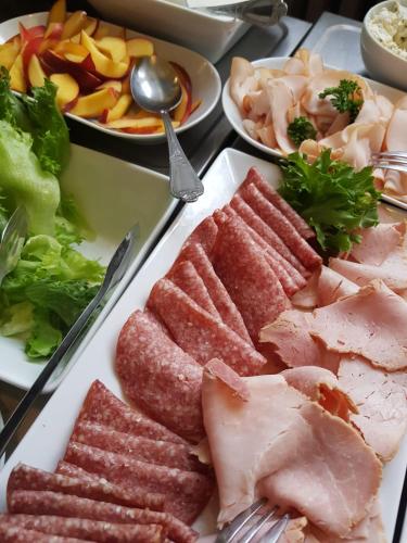 a plate of food with meat and vegetables on a table at Lentävä Kalakukko -Veturi B&B in Kuopio