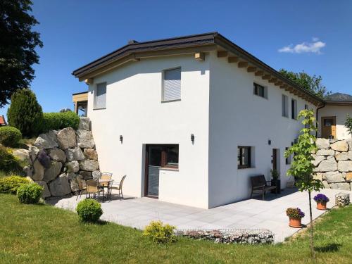 a white house with a stone wall at Appartement Antretter in Angerberg