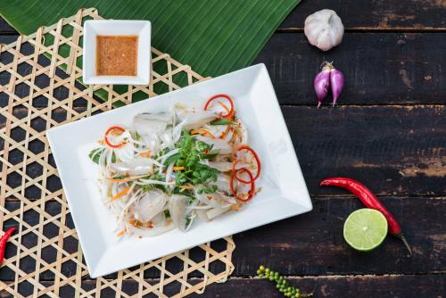 een witte plaat met groenten op een tafel bij Escalade Experience in Cam Ranh