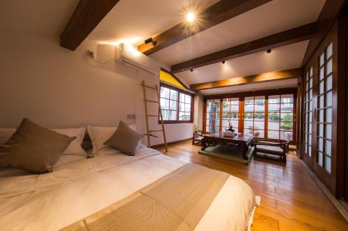 Xiamen Lanqin Gucuo Mansion في شيامن: غرفة نوم بسرير كبير في غرفة بها نوافذ