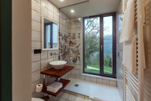 baño con lavabo y ventana en Eira Gundián, en Vedra