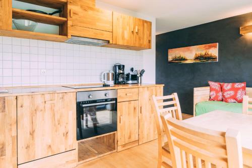 a kitchen with wooden cabinets and a table and a table and chairs at Gut Hügle Erlebnishof in Ravensburg