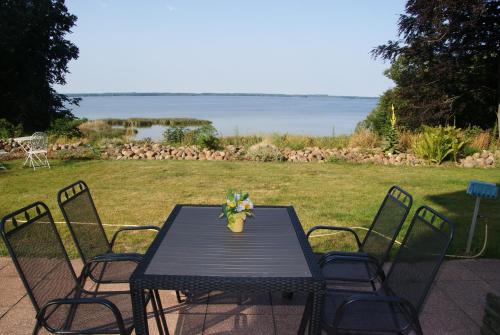 a black table and chairs with a view of the water at Ferienwohnung Seeblick in Waren