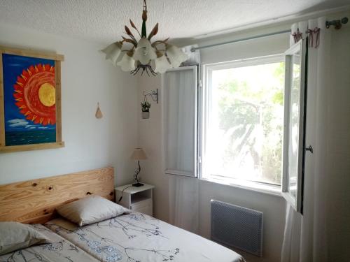 サラン・ド・ジローにあるLe Flamant Roseのベッドルーム(ベッド1台、窓付)
