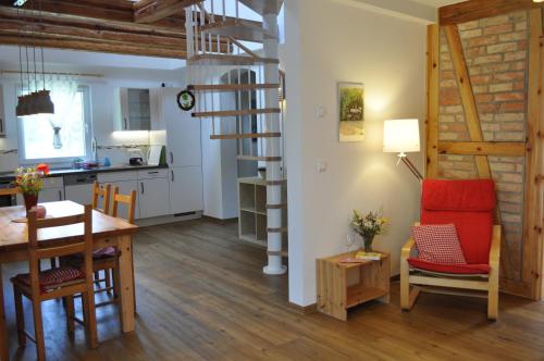 a kitchen and dining room with a spiral staircase in a room at Kulturfreizeiten Ferienwohnungen in Neuruppin