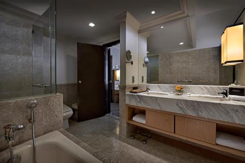 uma casa de banho com 2 lavatórios, uma banheira e um chuveiro em Berjaya Times Square Hotel, Kuala Lumpur em Kuala Lumpur