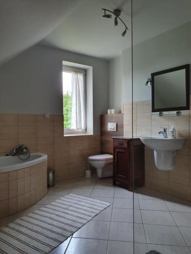 a bathroom with a tub toilet and a sink at Gosidomek in Zawoja