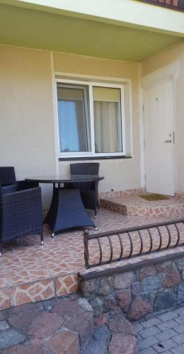 a patio with a table and chairs in front of a house at Vila Florena Garden in Palanga