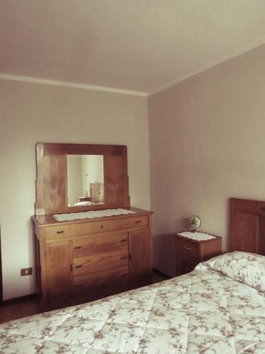 a bedroom with a bed and a dresser with a mirror at Locanda Genzianella in Gargnano