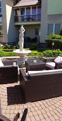 a fountain in front of a building with a building at Vila Florena Garden in Palanga