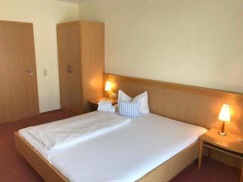 ein Schlafzimmer mit einem großen weißen Bett mit zwei Lampen in der Unterkunft Hotel Gasthof Rössle in Stetten am Kalten Markt