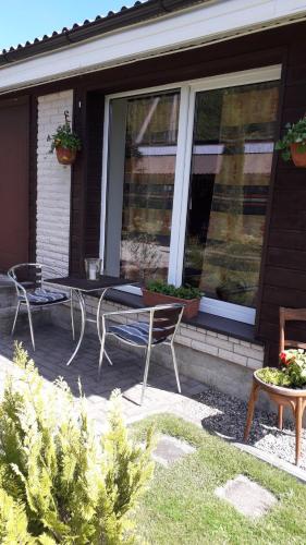 a patio with a table and chairs in front of a house at Tik Saviem in Palanga