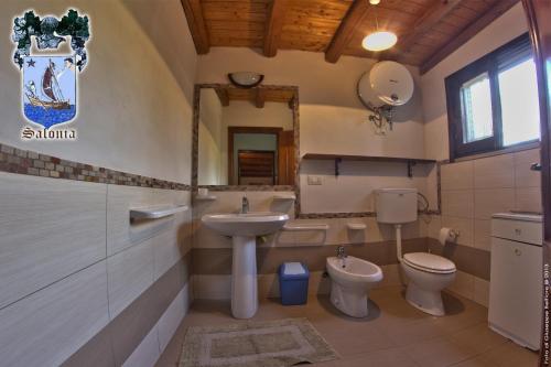uma casa de banho com lavatório, WC e espelho. em Alle Riserve Vendicari em Casa Maccari
