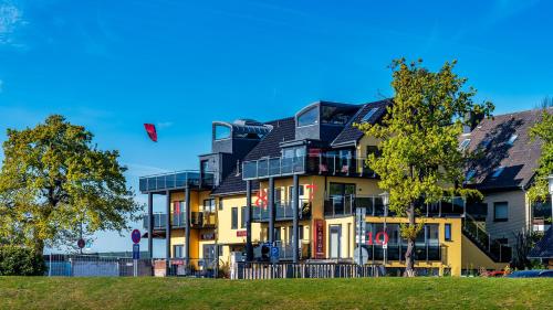 a large yellow building with a black roof at Seaside-Strandhotel in Timmendorfer Strand