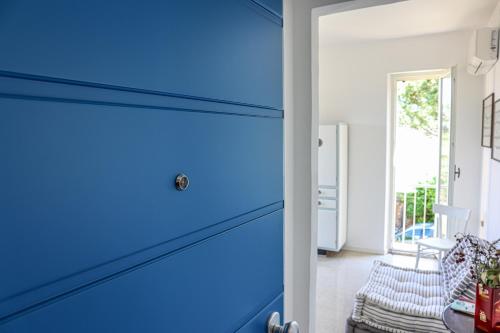 uma porta azul num quarto com uma cadeira em Sospeso fra cielo e mare em Cupra Marittima