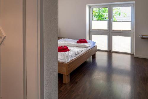 1 dormitorio con 1 cama con 2 almohadas rojas en Seaside-Strandhotel, en Timmendorfer Strand