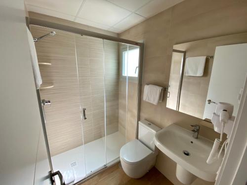 a bathroom with a toilet and a sink and a shower at Hostal Pensimar in El Altet