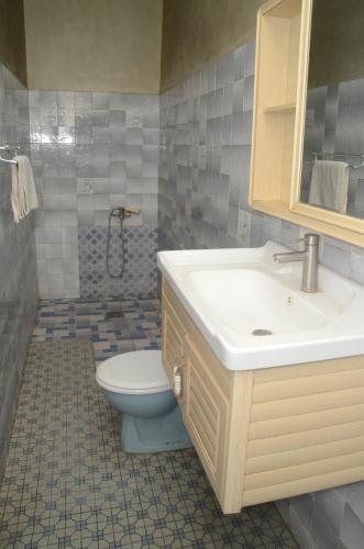 a bathroom with a sink and a toilet at Hotel Ambassadors in Lomé