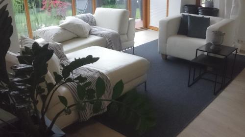 a living room with a couch and a chair at K82 apart HOTEL relax&work in Kirchentellinsfurt