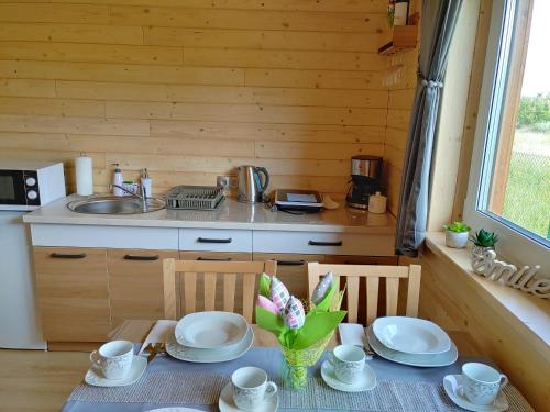 a kitchen with a table with plates and cups at Apartamenty przy Jeziorze Żywieckim z widokiem na Skrzyczne in Żywiec