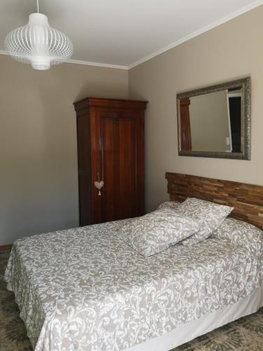 une chambre avec un lit et un miroir au mur dans l'établissement Chambre d'hôte Saint Rémy, à Aramon