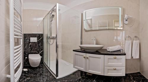 a bathroom with a sink and a toilet and a mirror at Apartmani D&D Sosič in Brela