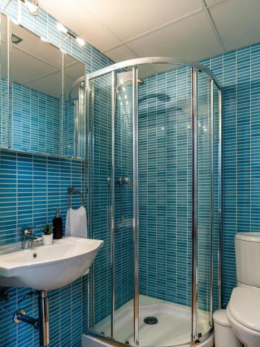 a bathroom with a sink and a shower with blue tiles at Casa Ignacio in Vejer de la Frontera