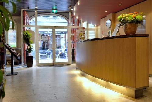 a lobby of a store with a counter with flowers at Best Western Dam Square Inn in Amsterdam