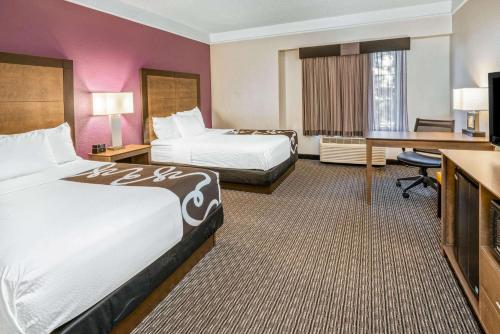 a hotel room with two beds and a desk at La Quinta by Wyndham Orem University Pwy Provo in Orem