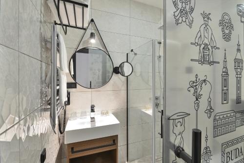 La salle de bains est pourvue d'un lavabo et d'un miroir. dans l'établissement Ramada by Wyndham Budapest City Center, à Budapest