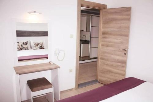 a bedroom with a bed and a desk and a door at Parla Apart Hotel in Cesme