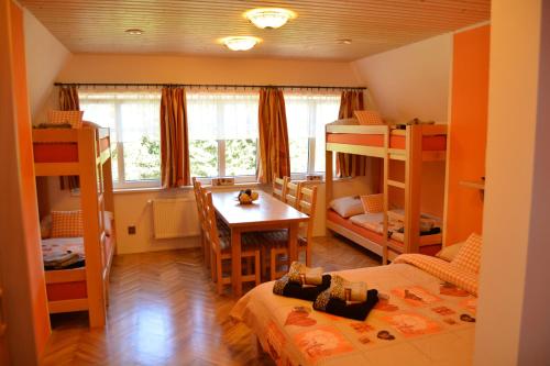 a room with bunk beds and a table and a dining room at Horská chata Milíře in Pec pod Sněžkou