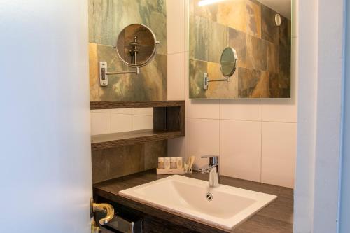 a bathroom with a sink and a mirror at Eden Studios and Apartments in Amsterdam