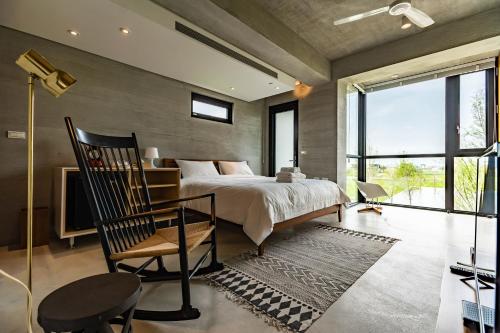 1 dormitorio con 1 cama, 1 silla y TV en Life in Nature en Wujie