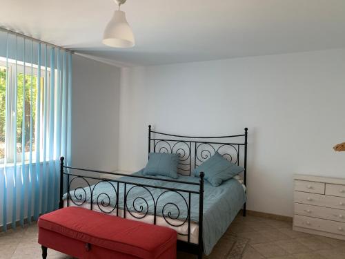 a bedroom with a black bed and a red ottoman at Yacht Club Apartamenty in Radzyń