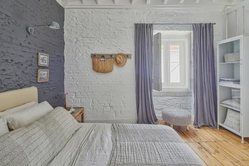 a bedroom with a bed and a brick wall at Casa Branca do Olival in Alcácer do Sal