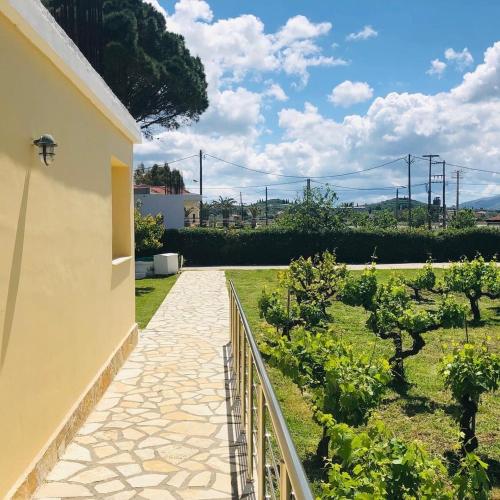 a stone walkway leading to a garden with trees at Beach House I&II in Alykes