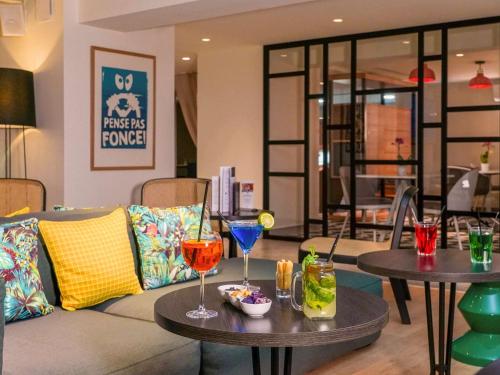 a living room with a couch and two tables with drinks at Mercure Marseille Centre Prado Vélodrome in Marseille