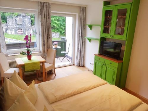 a room with a bed and a television and a table at Apartment Gastein in Bad Gastein