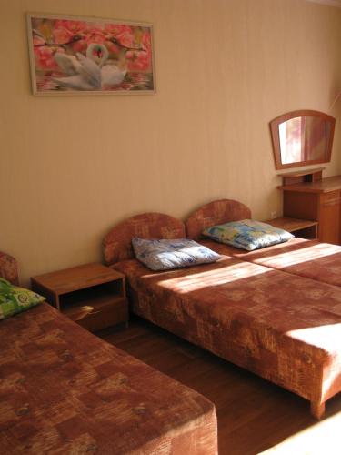 Habitación de hotel con 2 camas y sofá en Guest House u Timura, en Sudak